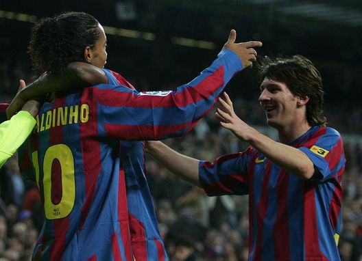 MADRID, SPAIN - NOVEMBER 19: Ronaldinho (L) of Barcelona celebrates with Lionel Messi after scoring a goal during the Primera Liga match between Real Madrid and F.C. Barcelona at the Bernabeu on November 19, 2005 in Madrid, Spain. (Photo by Denis Doyle/Getty Images) MADRID, SPAIN - NOVEMBER 19: Ronaldinho (L) of Barcelona celebrates with Lionel Messi after scoring a goal during the Primera Liga match between Real Madrid and F.C. Barcelona at the Bernabeu on November 19, 2005 in Madrid, Spain. (Photo by Denis Doyle/Getty Images)