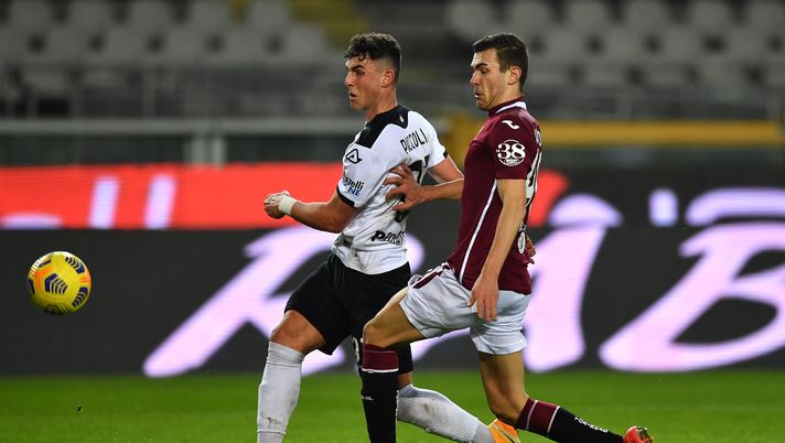 TURIN, ITALY - JANUARY 16: Roberto Piccoli of Spezia is challenged by Alessandro Buongiorno of Torino during the Serie A match between Torino FC and Spezia Calcio at Stadio Olimpico di Torino on January 16, 2021 in Turin, Italy. Sporting stadiums around Italy remain under strict restrictions due to the Coronavirus Pandemic as Government social distancing laws prohibit fans inside venues resulting in games being played behind closed doors. (Photo by Valerio Pennicino/Getty Images) TURIN, ITALY - JANUARY 16: Roberto Piccoli of Spezia is challenged by Alessandro Buongiorno of Torino during the Serie A match between Torino FC and Spezia Calcio at Stadio Olimpico di Torino on January 16, 2021 in Turin, Italy. Sporting stadiums around Italy remain under strict restrictions due to the Coronavirus Pandemic as Government social distancing laws prohibit fans inside venues resulting in games being played behind closed doors. (Photo by Valerio Pennicino/Getty Images)