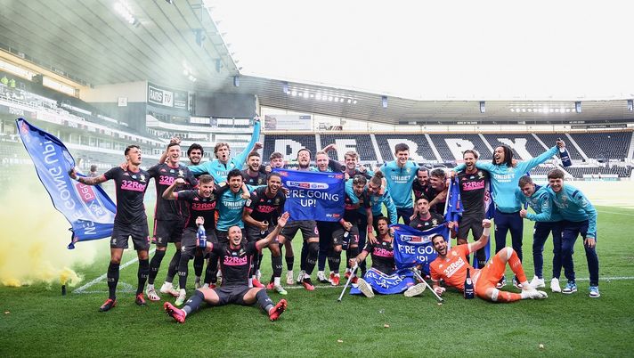 DERBY, ENGLAND - JULY 19: Leeds United celebrate winning the league and promotion to the premier league during the Sky Bet Championship match between Derby County and Leeds United at Pride Park Stadium on July 19, 2020 in Derby, England. Football Stadiums around Europe remain empty due to the Coronavirus Pandemic as Government social distancing laws prohibit fans inside venues resulting in all fixtures being played behind closed doors. (Photo by Laurence Griffiths/Getty Images) 