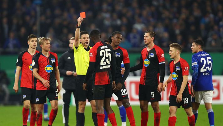 GELSENKIRCHEN, GERMANY - FEBRUARY 04: Referee Harm Osmers shows a red card to Jordan Torunarigha of Hertha BSC during the DFB Cup round of sixteen match between FC Schalke 04 and Hertha BSC at Veltins Arena on February 04, 2020 in Gelsenkirchen, Germany. (Photo by Dean Mouhtaropoulos/Bongarts/Getty Images) 