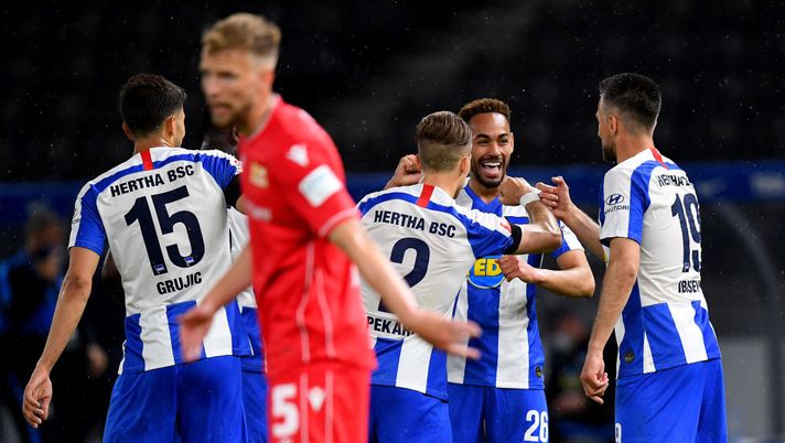 BERLIN, GERMANY - MAY 22: Matheus Santos Carneiro Da Cunha (C) of Hertha Berlin celebrate with his team mates after he scores the 3rd goal during the Bundesliga match between Hertha BSC and 1. FC Union Berlin at Olympiastadion on May 22, 2020 in Berlin, Germany. The Bundesliga and Second Bundesliga is the first professional league to resume the season after the nationwide lockdown due to the ongoing Coronavirus (COVID-19) pandemic. All matches until the end of the season will be played behind closed doors. (Photo by Stuart Franklin/Getty Images) BERLIN, GERMANY - MAY 22: Matheus Santos Carneiro Da Cunha (C) of Hertha Berlin celebrate with his team mates after he scores the 3rd goal during the Bundesliga match between Hertha BSC and 1. FC Union Berlin at Olympiastadion on May 22, 2020 in Berlin, Germany. The Bundesliga and Second Bundesliga is the first professional league to resume the season after the nationwide lockdown due to the ongoing Coronavirus (COVID-19) pandemic. All matches until the end of the season will be played behind closed doors. (Photo by Stuart Franklin/Getty Images)