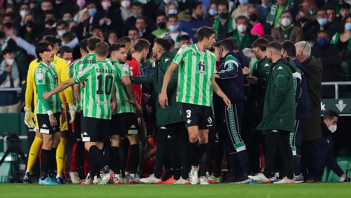 SEVILLE, SPAIN - JANUARY 15: Players gather around Joan Jordan of Sevilla FC after being hit by a stick thrown from the stand during the Real Betis Balompie and Sevilla Copa del Rey Round of 16 match at Estadio Benito Villamarin on January 15, 2022 in Seville, Spain. (Photo by Fran Santiago/Getty Images) Dopo il bastone in campo nel derby di Siviglia: arbitri spagnoli “Sospendere sempre subito…” - immagine 1