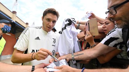 VILLAR PEROSA, ITALY - AUGUST 04: Federico Chiesa of Juventus signs autographs to Juventus fans during the Pre-Season Friendly between Juventus vs Juventus B on August 04, 2022 in Villar Perosa, Italy. (Photo by Chris Ricco - Juventus FC/Juventus FC via Getty Images)