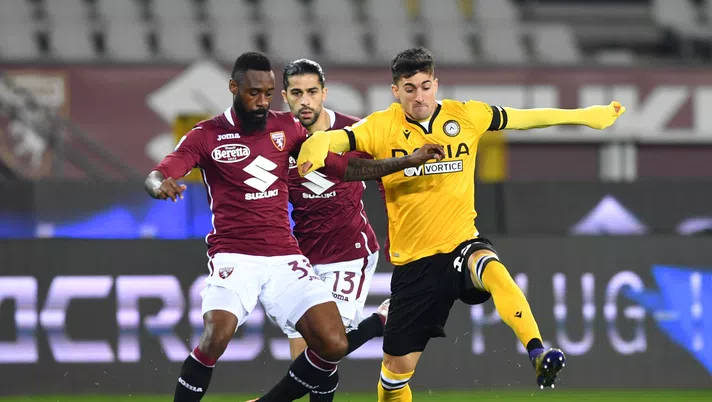 TURIN, ITALY - DECEMBER 12: Nicolas Nkoulou of Torino F.C. and Ignacio Pussetto of Udinese Calcio  battle for the ball  during the Serie A match between Torino FC and Udinese Calcio at Stadio Olimpico di Torino on December 12, 2020 in Turin, Italy. Sporting stadiums around Italy remain under strict restrictions due to the Coronavirus Pandemic as Government social distancing laws prohibit fans inside venues resulting in games being played behind closed doors. (Photo by Valerio Pennicino/Getty Images)