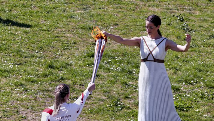 ATHENS, GREECE - MARCH 12: Greek actress Xanthi Georgiou, playing the role of High Priestess passes the flame to the first torchbearer, Greek shooting athlete Anna Korakaki, during the opening of the Olympic flame torch relay for the Tokyo 2020 Summer Olympics on March 12, 2020 in ancient Olympia. (Photo by Milos Bicanski/Getty Images) ATHENS, GREECE - MARCH 12: Greek actress Xanthi Georgiou, playing the role of High Priestess passes the flame to the first torchbearer, Greek shooting athlete Anna Korakaki, during the opening of the Olympic flame torch relay for the Tokyo 2020 Summer Olympics on March 12, 2020 in ancient Olympia. (Photo by Milos Bicanski/Getty Images)