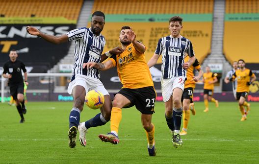  WOLVERHAMPTON, ENGLAND - JANUARY 16: Semi Ajayi of West Bromwich Albion is challenged by Patrick Cutrone of Wolverhampton Wanderers during the Premier League match between Wolverhampton Wanderers and West Bromwich Albion at Molineux on January 16, 2021 in Wolverhampton, England. Sporting stadiums around England remain under strict restrictions due to the Coronavirus Pandemic as Government social distancing laws prohibit fans inside venues resulting in games being played behind closed doors. (Photo by Shaun Botterill/Getty Images) 