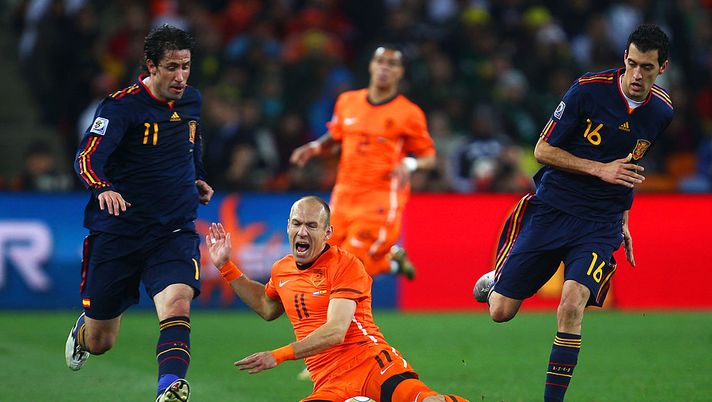 JOHANNESBURG, SOUTH AFRICA - JULY 11: Arjen Robben of the Netherlands falls to the ground after being tackled by Joan Capdevila (L) and Sergio Busquets of Spain during the 2010 FIFA World Cup South Africa Final match between Netherlands and Spain at Soccer City Stadium on July 11, 2010 in Johannesburg, South Africa. (Photo by Lars Baron/Getty Images) JOHANNESBURG, SOUTH AFRICA - JULY 11: Arjen Robben of the Netherlands falls to the ground after being tackled by Joan Capdevila (L) and Sergio Busquets of Spain during the 2010 FIFA World Cup South Africa Final match between Netherlands and Spain at Soccer City Stadium on July 11, 2010 in Johannesburg, South Africa. (Photo by Lars Baron/Getty Images)