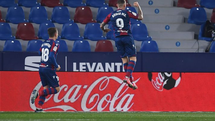 VALENCIA, SPAIN - MARCH 12: Roger of Levante celebrates scoring the 1st goal during the La Liga Santander match between Levante UD and Valencia CF at Ciutat de Valencia Stadium on March 12, 2021 in Valencia, Spain. Sporting stadiums around Spain remain under strict restrictions due to the Coronavirus Pandemic as Government social distancing laws prohibit fans inside venues resulting in games being played behind closed doors. (Photo by Alex Caparros/Getty Images) VALENCIA, SPAIN - MARCH 12: Roger of Levante celebrates scoring the 1st goal during the La Liga Santander match between Levante UD and Valencia CF at Ciutat de Valencia Stadium on March 12, 2021 in Valencia, Spain. Sporting stadiums around Spain remain under strict restrictions due to the Coronavirus Pandemic as Government social distancing laws prohibit fans inside venues resulting in games being played behind closed doors. (Photo by Alex Caparros/Getty Images)