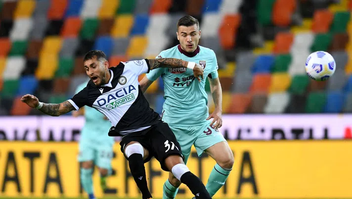 UDINE, ITALY - APRIL 10: Roberto Pereyra of Udinese Calcio is tackled by Alessandro Buongiorno of Torino FC during the Serie A match between Udinese Calcio  and Torino FC at Dacia Arena on April 10, 2021 in Udine, Italy. Sporting stadiums around Italy remain under strict restrictions due to the Coronavirus Pandemic as Government social distancing laws prohibit fans inside venues resulting in games being played behind closed doors.  (Photo by Alessandro Sabattini/Getty Images)