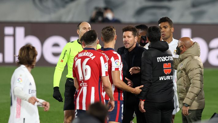 MADRID, SPAIN - DECEMBER 12: Marcos Llorente of Atletico de Madrid (obscured) appeals to match referee Antonio Miguel Mateu Lahoz as Diego Simeone, Head Coach of Atletico de Madrid holds him back during the La Liga Santander match between Real Madrid and Atletico de Madrid at Estadio Alfedo Di Stefano on December 12, 2020 in Madrid, Spain. Sporting stadiums around Spain remain under strict restrictions due to the Coronavirus Pandemic as Government social distancing laws prohibit fans inside venues resulting in games being played behind closed doors. (Photo by Angel Martinez/Getty Images) MADRID, SPAIN - DECEMBER 12: Marcos Llorente of Atletico de Madrid (obscured) appeals to match referee Antonio Miguel Mateu Lahoz as Diego Simeone, Head Coach of Atletico de Madrid holds him back during the La Liga Santander match between Real Madrid and Atletico de Madrid at Estadio Alfedo Di Stefano on December 12, 2020 in Madrid, Spain. Sporting stadiums around Spain remain under strict restrictions due to the Coronavirus Pandemic as Government social distancing laws prohibit fans inside venues resulting in games being played behind closed doors. (Photo by Angel Martinez/Getty Images)