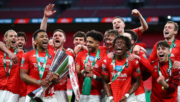 LONDON, ENGLAND - MARCH 13: Ibou Touray of Salford City and his teammates celebrate with the EFL Trophy following their team's victory in the EFL Trophy Final at Wembley Stadium on March 13, 2021 in London, England. The teams were due to meet in April 2020, but the original final was postponed because of the coronavirus pandemic. Sporting stadiums around the UK remain under strict restrictions due to the Coronavirus Pandemic as Government social distancing laws prohibit fans inside venues resulting in games being played behind closed doors. (Photo by Bryn Lennon/Getty Images) LONDON, ENGLAND - MARCH 13: Ibou Touray of Salford City and his teammates celebrate with the EFL Trophy following their team's victory in the EFL Trophy Final at Wembley Stadium on March 13, 2021 in London, England. The teams were due to meet in April 2020, but the original final was postponed because of the coronavirus pandemic. Sporting stadiums around the UK remain under strict restrictions due to the Coronavirus Pandemic as Government social distancing laws prohibit fans inside venues resulting in games being played behind closed doors. (Photo by Bryn Lennon/Getty Images)