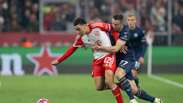 MUNICH, GERMANY - MARCH 05: Jamal Musiala of FC Bayern München is tackled by Adam Marusic of SS Lazio during the UEFA Champions League 2023/24 round of 16 second leg match between FC Bayern München and SS Lazio at Allianz Arena on March 05, 2024 in Munich, Germany. (Photo by Christian Kaspar-Bartke/Getty Images) Champions, Bayern-Lazio è l’ottavo meno visto negli ultimi 10 anni in chiaro - immagine 1