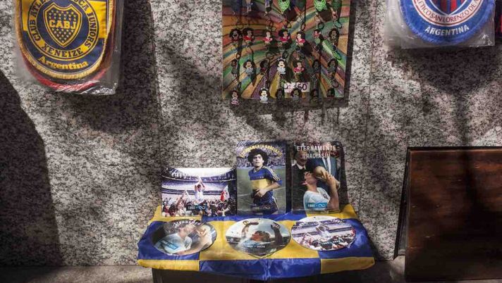 BUENOS AIRES, ARGENTINA - NOVEMBER 26: Street vendors sell merchandise to fans of late Diego Maradona at line pass to Casa Rosada on November 26, 2020 in Buenos Aires, Argentina. Maradona died of a heart attack at his home on Thursday 25 aged 60 . He is considered among the best footballers in history and lead his national team to the World Cup in 1986. President of Argentina Alberto Fernandez declared three days of national mourning. (Photo by Ricardo Ceppi/Getty Images) BUENOS AIRES, ARGENTINA - NOVEMBER 26: Street vendors sell merchandise to fans of late Diego Maradona at line pass to Casa Rosada on November 26, 2020 in Buenos Aires, Argentina. Maradona died of a heart attack at his home on Thursday 25 aged 60 . He is considered among the best footballers in history and lead his national team to the World Cup in 1986. President of Argentina Alberto Fernandez declared three days of national mourning. (Photo by Ricardo Ceppi/Getty Images)