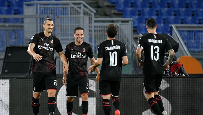 ROME, ITALY - JULY 04: Hakan Calhanoglu of AC Milan celebrates after scoring the opening goal with teammates during the Serie A match between SS Lazio and AC Milan at Stadio Olimpico on July 04, 2020 in Rome, Italy. (Photo by Marco Rosi - SS Lazio/Getty Images) ROME, ITALY - JULY 04: Hakan Calhanoglu of AC Milan celebrates after scoring the opening goal with teammates during the Serie A match between SS Lazio and AC Milan at Stadio Olimpico on July 04, 2020 in Rome, Italy. (Photo by Marco Rosi - SS Lazio/Getty Images)