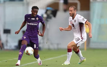  FLORENCE, ITALY - JULY 19: Christian Kouame of ACF Fiorentina battles for the ball with Lorenzo De Silvestri of Torino FC during the Serie A match between ACF Fiorentina and Torino FC at Stadio Artemio Franchi on July 19, 2020 in Florence, Italy. (Photo by Gabriele Maltinti/Getty Images)