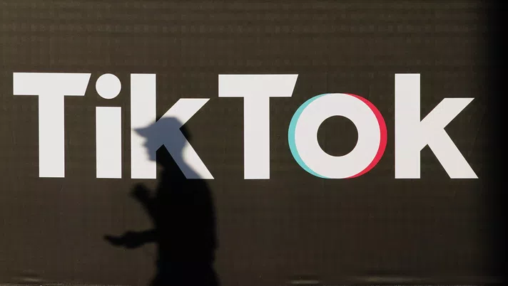 BERLIN, GERMANY - SEPTEMBER 21: A young man holding a smartphone casts a shadow as he walks past an advertisement for social media company TikTok on September 21, 2020 in Berlin, Germany. U.S. President Donald Trump has given preliminary approval for Oracle, Walmart and other investors to take over TikTok and create a new U.S.-based company called TikTok Global. (Photo by Sean Gallup/Getty Images)