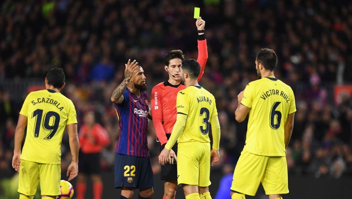 BARCELONA, SPAIN - DECEMBER 02: Arturo Vidal of Barcelona (22) appeals as referee Jose Luis Munuera Montero shows a yellow card to Alvaro Gonzalez of Villareal (3) after a foul on Lionel Messi of Barcelona (grounded) during the La Liga match between FC Barcelona and Villarreal CF at Camp Nou on December 2, 2018 in Barcelona, Spain. (Photo by David Ramos/Getty Images) BARCELONA, SPAIN - DECEMBER 02: Arturo Vidal of Barcelona (22) appeals as referee Jose Luis Munuera Montero shows a yellow card to Alvaro Gonzalez of Villareal (3) after a foul on Lionel Messi of Barcelona (grounded) during the La Liga match between FC Barcelona and Villarreal CF at Camp Nou on December 2, 2018 in Barcelona, Spain. (Photo by David Ramos/Getty Images)