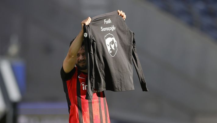 FRANKFURT AM MAIN, GERMANY - FEBRUARY 20: Amin Younes of Eintracht Frankfurt celebrates scoring their side's second goal by holding up a t shirt with the name 'Fatih Saracoglu', a victim of the Hanau shooting during the Bundesliga match between Eintracht Frankfurt and FC Bayern Muenchen at Deutsche Bank Park on February 20, 2021 in Frankfurt am Main, Germany. Sporting stadiums around Germany remain under strict restrictions due to the Coronavirus Pandemic as Government social distancing laws prohibit fans inside venues resulting in games being played behind closed doors. (Photo by Ronald Wittek - Pool/Getty Images) FRANKFURT AM MAIN, GERMANY - FEBRUARY 20: Amin Younes of Eintracht Frankfurt celebrates scoring their side's second goal by holding up a t shirt with the name 'Fatih Saracoglu', a victim of the Hanau shooting during the Bundesliga match between Eintracht Frankfurt and FC Bayern Muenchen at Deutsche Bank Park on February 20, 2021 in Frankfurt am Main, Germany. Sporting stadiums around Germany remain under strict restrictions due to the Coronavirus Pandemic as Government social distancing laws prohibit fans inside venues resulting in games being played behind closed doors. (Photo by Ronald Wittek - Pool/Getty Images)