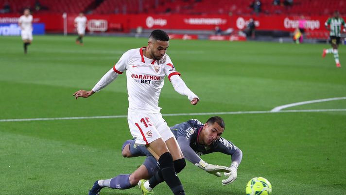 SEVILLE, SPAIN - MARCH 14: Yousseff En-Nesyri of Sevilla scores their side's first goal as he is challenged by Joel Robles of Real Betis during the La Liga Santander match between Sevilla FC and Real Betis at Estadio Ramon Sanchez Pizjuan on March 14, 2021 in Seville, Spain. Sporting stadiums around Spain remain under strict restrictions due to the Coronavirus Pandemic as Government social distancing laws prohibit fans inside venues resulting in games being played behind closed doors. (Photo by Fran Santiago/Getty Images) SEVILLE, SPAIN - MARCH 14: Yousseff En-Nesyri of Sevilla scores their side's first goal as he is challenged by Joel Robles of Real Betis during the La Liga Santander match between Sevilla FC and Real Betis at Estadio Ramon Sanchez Pizjuan on March 14, 2021 in Seville, Spain. Sporting stadiums around Spain remain under strict restrictions due to the Coronavirus Pandemic as Government social distancing laws prohibit fans inside venues resulting in games being played behind closed doors. (Photo by Fran Santiago/Getty Images)