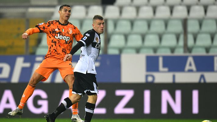 PARMA, ITALY - DECEMBER 19: Cristiano Ronaldo of Juventus F.C. scores their team's third goal under pressure from Simone Iacoponi of Parma Calcio during the Serie A match between Parma Calcio and Juventus at Stadio Ennio Tardini on December 19, 2020 in Parma, Italy. Sporting stadiums around Italy remain under strict restrictions due to the Coronavirus Pandemic as Government social distancing laws prohibit fans inside venues resulting in games being played behind closed doors. (Photo by Alessandro Sabattini/Getty Images) PARMA, ITALY - DECEMBER 19: Cristiano Ronaldo of Juventus F.C. scores their team's third goal under pressure from Simone Iacoponi of Parma Calcio during the Serie A match between Parma Calcio and Juventus at Stadio Ennio Tardini on December 19, 2020 in Parma, Italy. Sporting stadiums around Italy remain under strict restrictions due to the Coronavirus Pandemic as Government social distancing laws prohibit fans inside venues resulting in games being played behind closed doors. (Photo by Alessandro Sabattini/Getty Images)