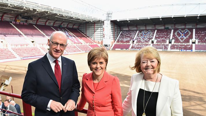 EDINBURGH, SCOTLAND - MAY 26: First Minister of Scotland and leader of the SNP Nicola Sturgeon (C) arrives with Chairwoman and chief executive of Hearts Football Club Ann Budge and Deputy First Minister of Scotland John Swinney arrive during a visit to the the Heart of Midlothian FC's Tynecastle Stadium on May 26, 2015 in Edinburgh, Scotland. During her visit the First Minister launched The Scottish Business Pledge and made her first major economic speech since the outcome of the UK General Election, attacking the scale and speed of spending cuts planned by the UK government. She also reiterated the SNP's support for staying a member of the European Union. (Photo by Jeff J Mitchell/Getty Images) EDINBURGH, SCOTLAND - MAY 26: First Minister of Scotland and leader of the SNP Nicola Sturgeon (C) arrives with Chairwoman and chief executive of Hearts Football Club Ann Budge and Deputy First Minister of Scotland John Swinney arrive during a visit to the the Heart of Midlothian FC's Tynecastle Stadium on May 26, 2015 in Edinburgh, Scotland. During her visit the First Minister launched The Scottish Business Pledge and made her first major economic speech since the outcome of the UK General Election, attacking the scale and speed of spending cuts planned by the UK government. She also reiterated the SNP's support for staying a member of the European Union. (Photo by Jeff J Mitchell/Getty Images)