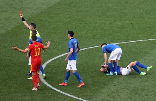 ROME, ITALY - JUNE 20: Match Referee, Ovidiu Hategan shows Ethan Ampadu of Wales (not pictured) a red card as Federico Bernardeschi of Italy lies injured following a foul during the UEFA Euro 2020 Championship Group A match between Italy and Wales at Olimpico Stadium on June 20, 2021 in Rome, Italy. (Photo by Ryan Pierse/Getty Images) ROME, ITALY - JUNE 20: Match Referee, Ovidiu Hategan shows Ethan Ampadu of Wales (not pictured) a red card as Federico Bernardeschi of Italy lies injured following a foul during the UEFA Euro 2020 Championship Group A match between Italy and Wales at Olimpico Stadium on June 20, 2021 in Rome, Italy. (Photo by Ryan Pierse/Getty Images)