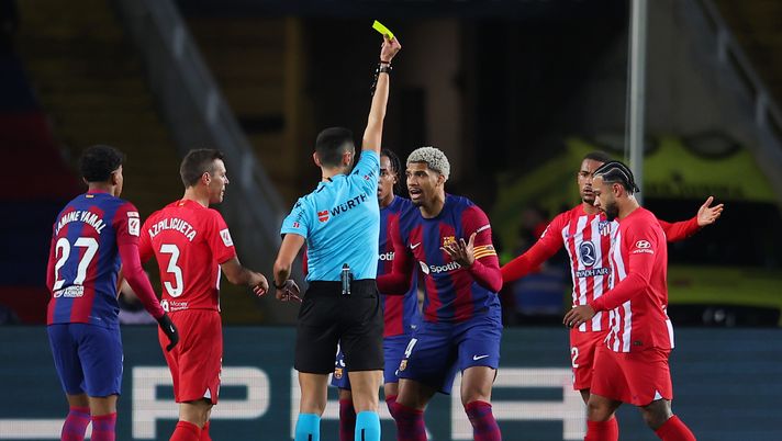 BARCELONA, SPAIN - DECEMBER 03: Ronald Araujo of FC Barcelona is shown a yellow card by Referee Jose Maria Sanchez Martinez during the LaLiga EA Sports match between FC Barcelona and Atletico Madrid at Estadi Olimpic Lluis Companys on December 03, 2023 in Barcelona, Spain. (Photo by Eric Alonso/Getty Images) Liga, Atletico-Barcellona sa di spareggio per Champions… e Mondiale per Club - immagine 1