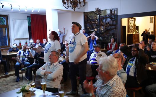I tifosi e il match in un bar al di fuori dell'Olympiastadion durante ll derby 