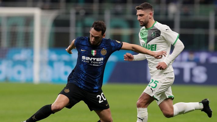 MILAN, ITALY - FEBRUARY 20: Hakan Calhanoglu of FC Internazionale battles for possession with Domenico Berardi of US Sassuolo during the Serie A match between FC Internazionale and US Sassuolo at Stadio Giuseppe Meazza on February 20, 2022 in Milan, Italy. (Photo by Emilio Andreoli - Inter/Inter via Getty Images)