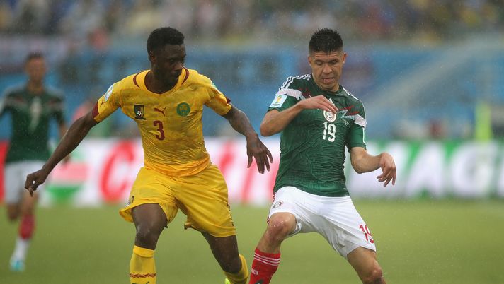NATAL, BRAZIL - JUNE 13:  Nicolas N'Koulou of Cameroon battles with Oribe Peralta of Mexico during the 2014 FIFA World Cup Brazil Group A match between Mexico and Cameroon at Estadio das Dunas on June 13, 2014 in Natal, Brazil.  (Photo by Clive Rose/Getty Images) 
