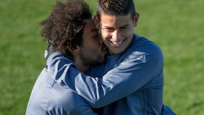 Real Madrid's Brazilian defender Marcelo (L) kisses Real Madrid's Colombian midfielder James Rodriguez as they attend a training session on the eve of the UEFA Champions league football match Real Madrid vs Borussia Dortmund at the Real Madrid's training ground of Valdebebas in Madrid on December 6, 2016. / AFP / CURTO DE LA TORRE (Photo credit should read CURTO DE LA TORRE/AFP/Getty Images) James Rodriguez, la Gazzetta rivela: “Carlo Ancelotti non smette di sperare” - immagine 1