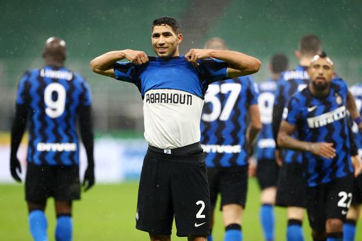MILAN, ITALY - DECEMBER 05: Achraf Hakimi of Inter Milan celebrates after scoring their team's second goal whilst showing a t-shirt in memory of ex-Moroccan player Mohamed Aberhoun during the Serie A match between FC Internazionale and Bologna FC at Stadio Giuseppe Meazza on December 05, 2020 in Milan, Italy. Football Stadiums around Italy remain empty due to the Coronavirus Pandemic as Government social distancing laws prohibit fans inside venues resulting in fixtures being played behind closed doors. (Photo by Marco Luzzani/Getty Images) MILAN, ITALY - DECEMBER 05: Achraf Hakimi of Inter Milan celebrates after scoring their team's second goal whilst showing a t-shirt in memory of ex-Moroccan player Mohamed Aberhoun during the Serie A match between FC Internazionale and Bologna FC at Stadio Giuseppe Meazza on December 05, 2020 in Milan, Italy. Football Stadiums around Italy remain empty due to the Coronavirus Pandemic as Government social distancing laws prohibit fans inside venues resulting in fixtures being played behind closed doors. (Photo by Marco Luzzani/Getty Images)