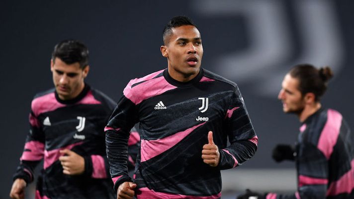 TURIN, ITALY - MARCH 09: Alex Sandro of Juventus warms up prior to the UEFA Champions League Round of 16 match between Juventus and FC Porto at Juventus Arena on March 09, 2021 in Turin, Italy. Sporting stadiums around Italy remain under strict restrictions due to the Coronavirus Pandemic as Government social distancing laws prohibit fans inside venues resulting in games being played behind closed doors. (Photo by Valerio Pennicino/Getty Images) Da Kaio Jorge e Alex Sandro a Bonucci e Pellegrini: chi recupera e chi no nella Juventus - immagine 1