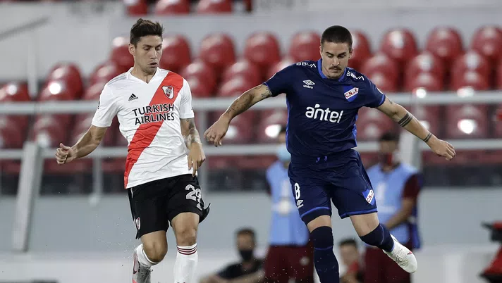 AVELLANEDA, ARGENTINA - DECEMBER 10: Gonzalo Montiel of River Plate competes for the ball with Gabriel Neves of Nacional during a first leg match between River Plate and Nacional as part of Copa CONMEBOL Libertadores 2020 quarter finals on December 10, 2020 in Avellaneda, Argentina. (Photo by Juan I. Roncoroni - Pool/Getty Images)