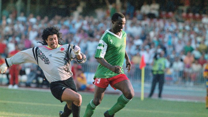 NAPLES, ITALY - JUNE 23: Cameroon striker Roger Milla walks the ball into the empty net to score the winning goal after dispossesing Colombian goalkeeper Rene Higuita (l) of the ball mid pitch during the Second phase match between Cameroon and Colombia on June 23, in Naples, Italy. (Photo by Allsport/Getty Images) NAPLES, ITALY - JUNE 23: Cameroon striker Roger Milla walks the ball into the empty net to score the winning goal after dispossesing Colombian goalkeeper Rene Higuita (l) of the ball mid pitch during the Second phase match between Cameroon and Colombia on June 23, in Naples, Italy. (Photo by Allsport/Getty Images)