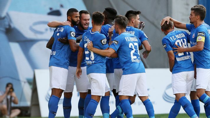 ROSTOCK, GERMANY - AUGUST 03:  Cebio Soukou (L) of Rostock celebrates with team mates after scoring the first goal during the 3.Liga match between FC Hansa Rostock and Eintracht Braunschweig at Ostseestadion on August 3, 2018 in Rostock, Germany. (Photo by Matthias Kern/Bongarts/Getty Images) 