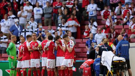 COPENHAGEN, DENMARK - JUNE 12: Players of Denmark stand dejected as Christian Eriksen (Hidden) of Denmark receives medical treatment during the UEFA Euro 2020 Championship Group B match between Denmark and Finland on June 12, 2021 in Copenhagen, Denmark. (Photo by Friedemann Vogel - Pool/Getty Images)