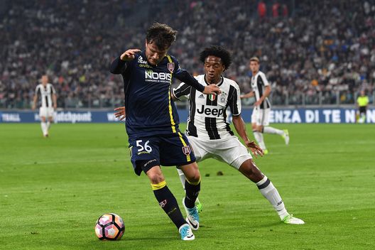  TURIN, ITALY - APRIL 08: Juan Cuadrado (R) of Juventus FC competes with Ivan Radovanovic of AC ChievoVerona during the Serie A match between Juventus FC and AC ChievoVerona at Juventus Stadium on April 8, 2017 in Turin, Italy. (Photo by Valerio Pennicino/Getty Images) 