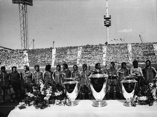 12th May 1976: Winners for the third time, the players of Bayern Munich football club stand in front of the three cups in the Munich Olympic stadium, with the original in the middle. (Photo by Keystone/Getty Images) 12th May 1976: Winners for the third time, the players of Bayern Munich football club stand in front of the three cups in the Munich Olympic stadium, with the original in the middle. (Photo by Keystone/Getty Images)